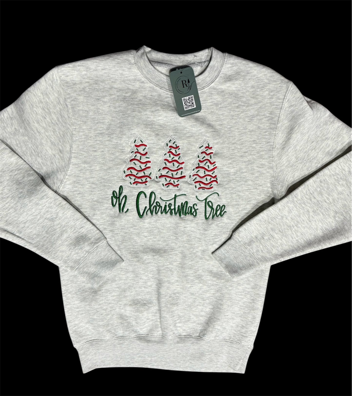 Heathered gray sweatshirt with 3 Christmas trees embroidered in white, red, and green tree shape in a line with the text 'Oh, Christmas Tree' embroidered in green underneath. This view is a zoomed out view with the entire sweatshirt in view sleeves folded on top.