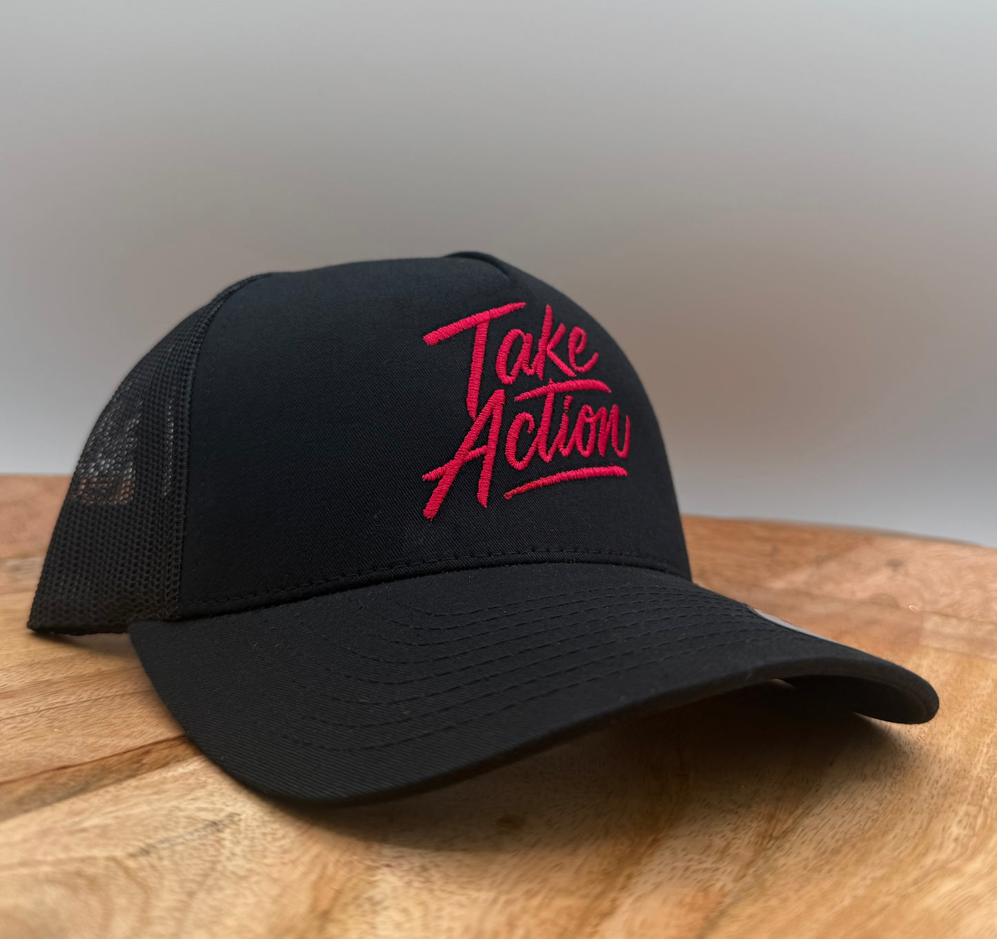 Black hat with the text 'Take Action' embroidered in red