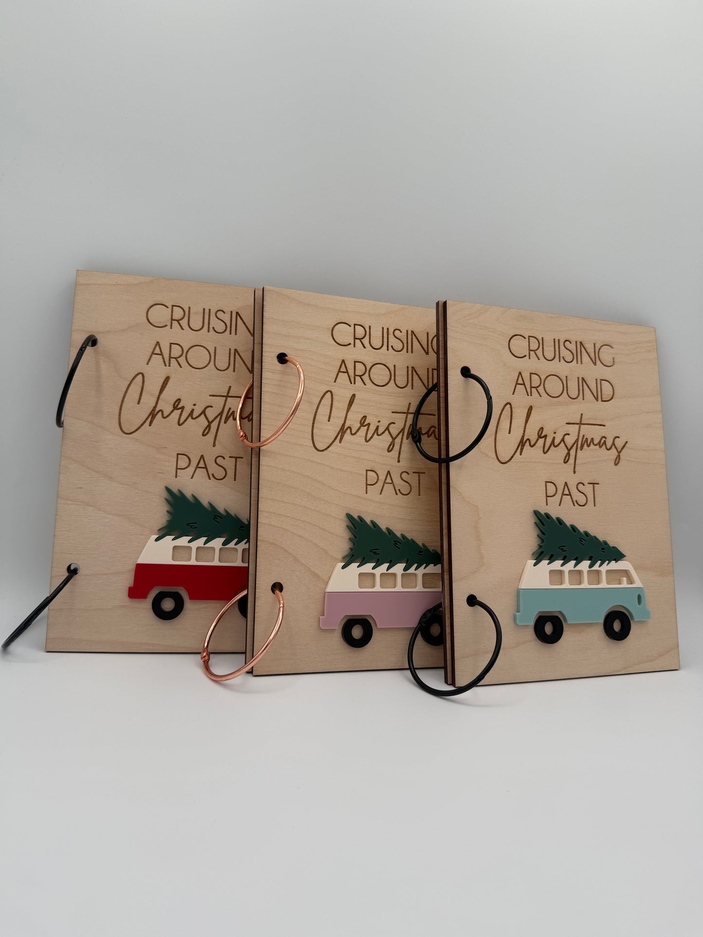 Three wooden Christmas greeting card keepers with an acrylic retro van carrying a christmas tree design. The words 'Cruising Around Christmas Past' is laser engraved on the top.