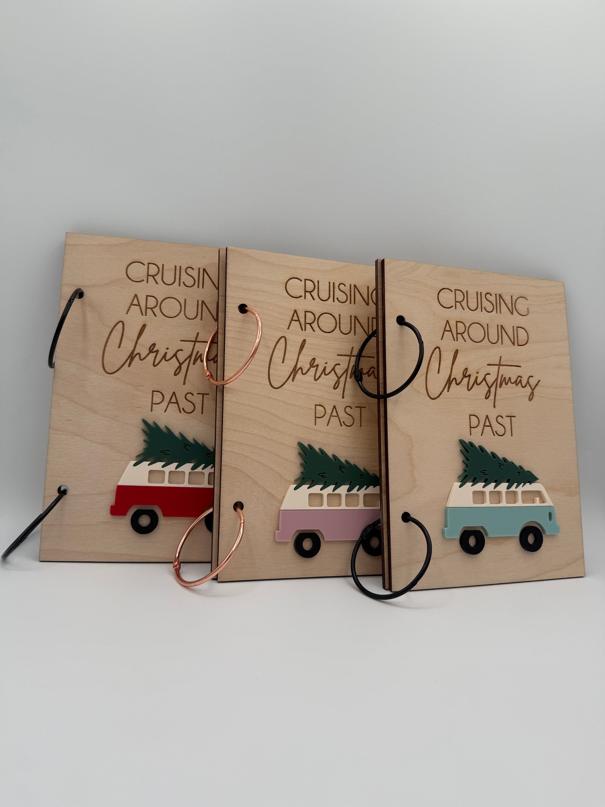 Three wooden Christmas greeting card keepers with an acrylic retro van carrying a christmas tree design. The words 'Cruising Around Christmas Past' is laser engraved on the top.