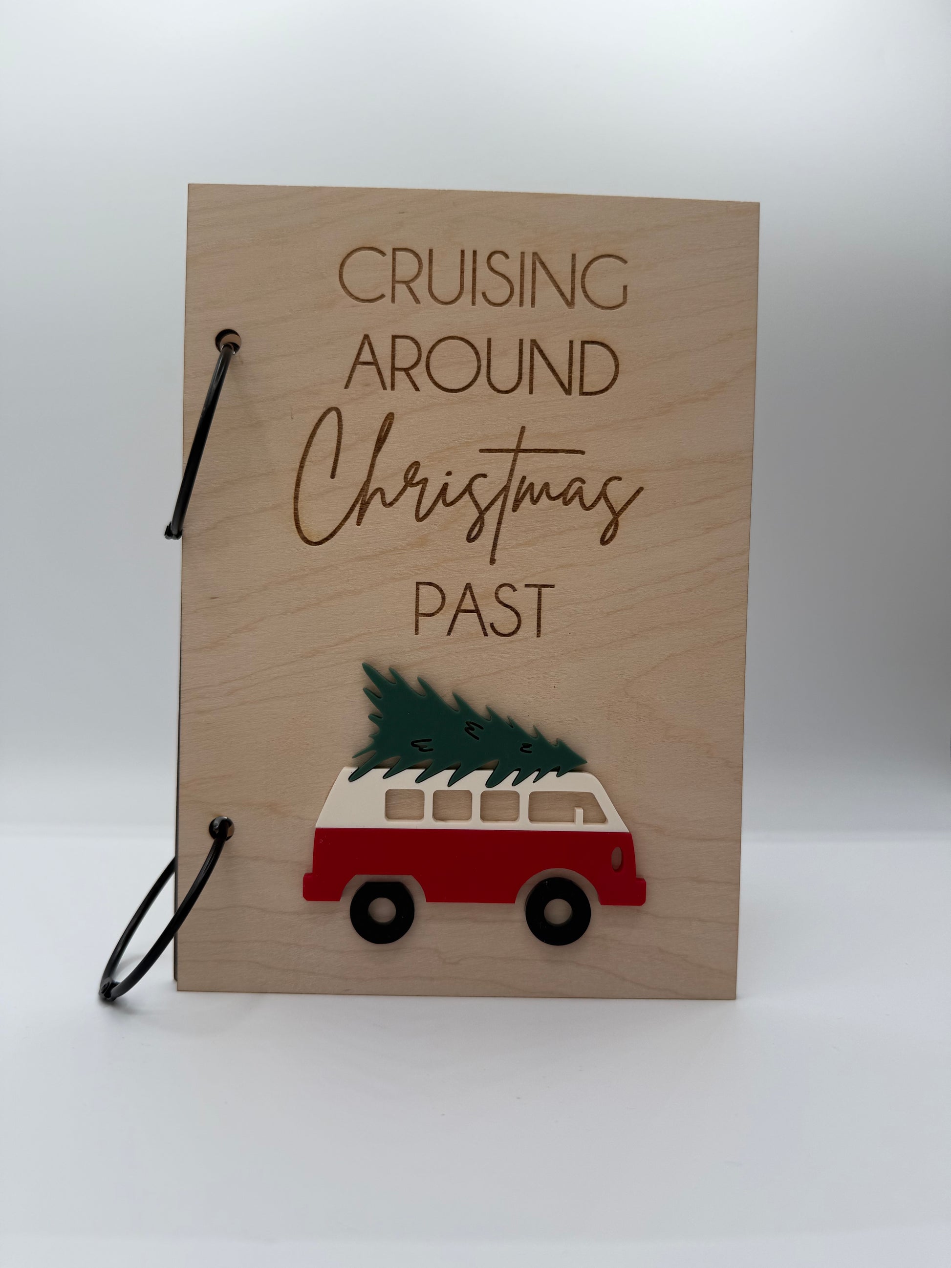  Wooden Christmas greeting card keeper with an acrylic red retro van carrying a christmas tree design. The words 'Cruising Around Christmas Past' is laser engraved on the top with black binder rings.