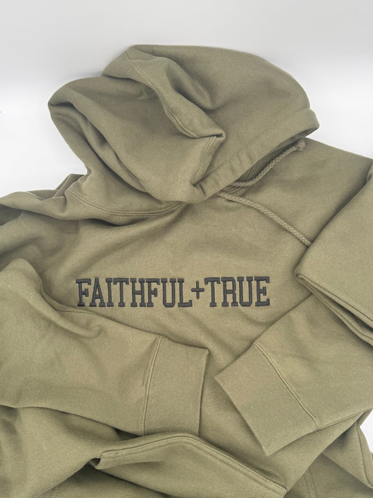 A tan hooded sweatshirt with the words 'Faithful + True' embroidered in black on the front center chest.