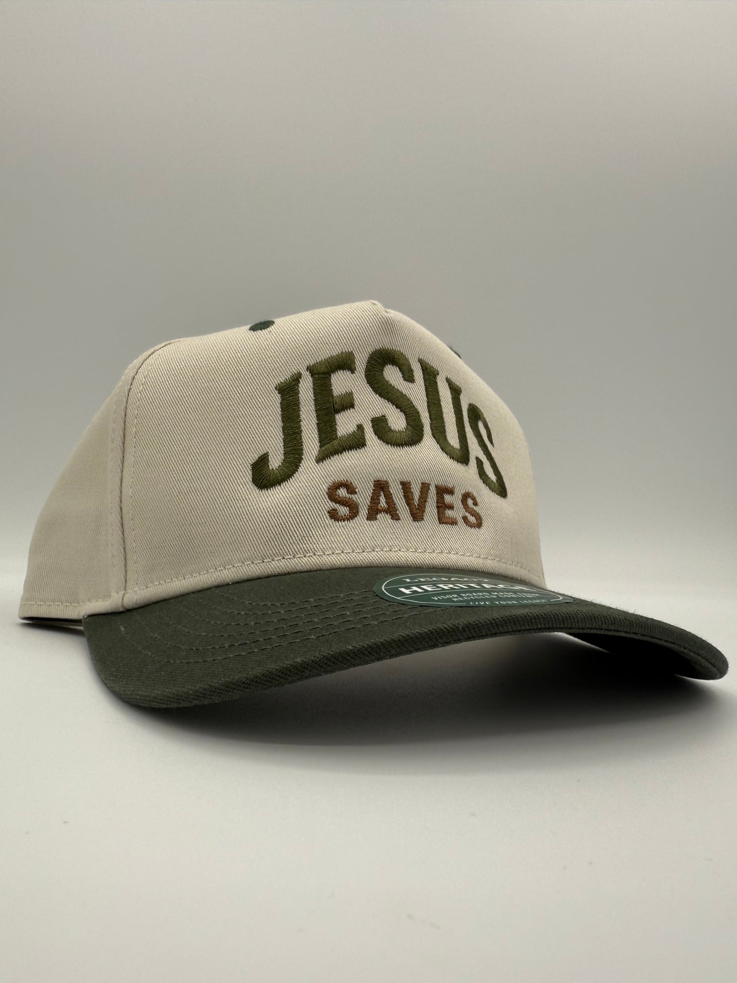 Tan and green two toned hat with the words 'Jesus Saves' embroidered on the front side profile