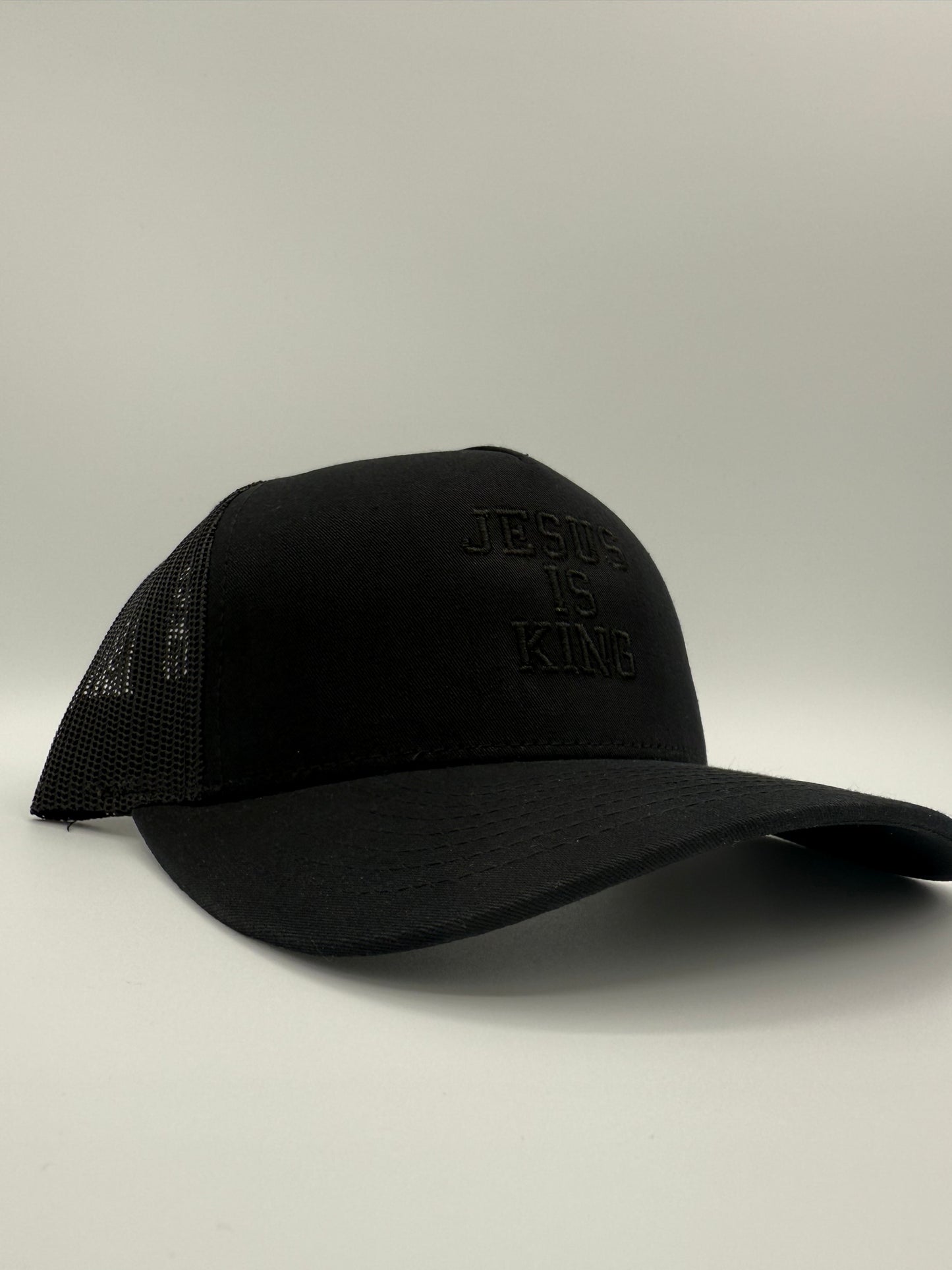 Black hat with the words 'Jesus is King' embroidered in black on a white background.
