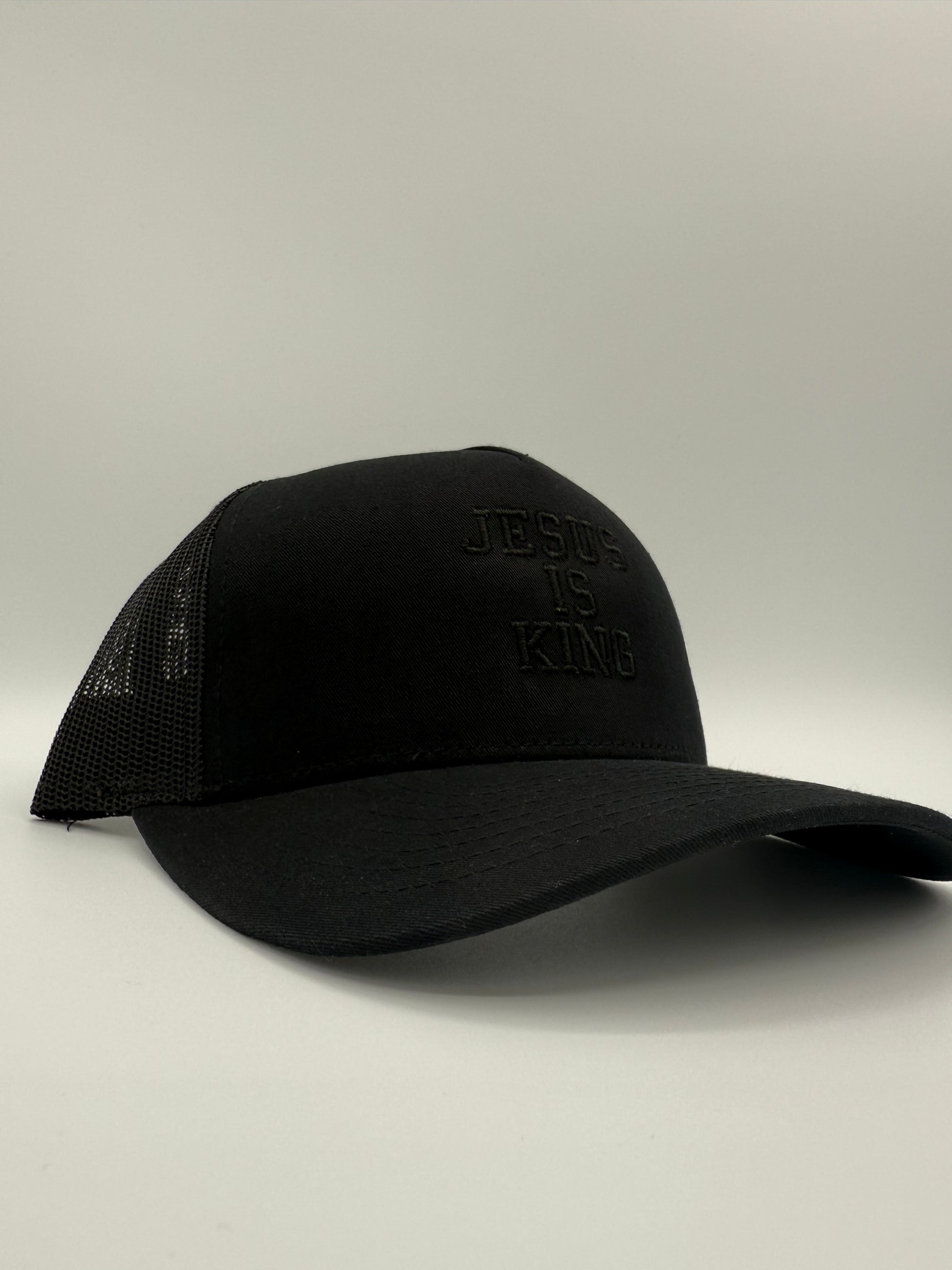 Black hat with the words 'Jesus is King' embroidered in black on a white background.