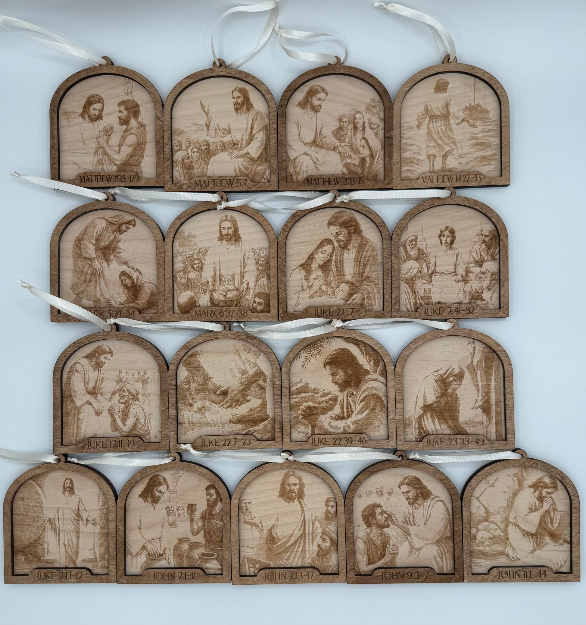 Set of wooden ornaments that depict laser engraved scenes throughout the life of Jesus. Each ornament has the specific bible verse engraved that the scene depicts.