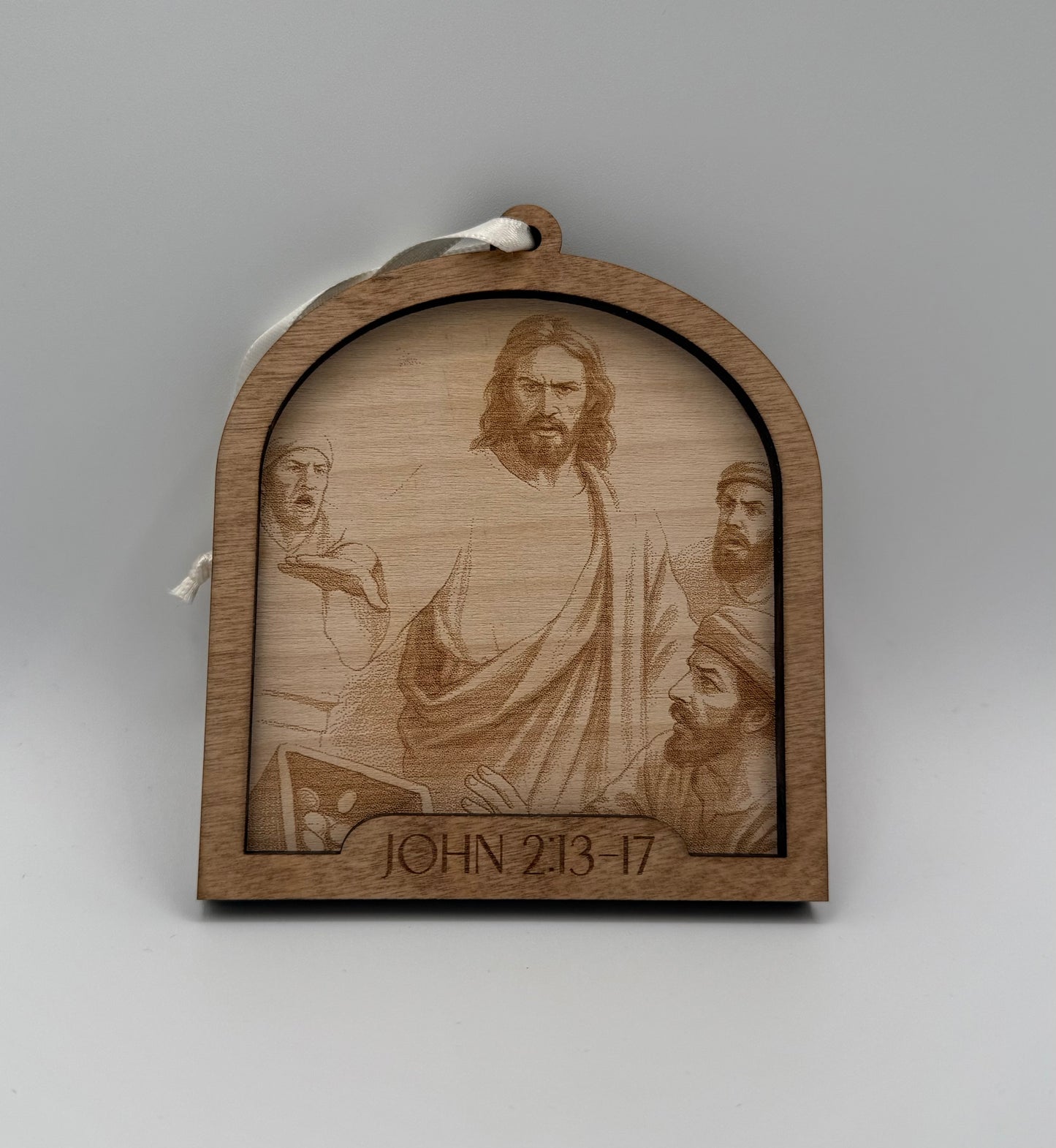 Wooden ornament with a laser engraved scene depicting Jesus talking to a three men. Bible verses John 2:13-17.