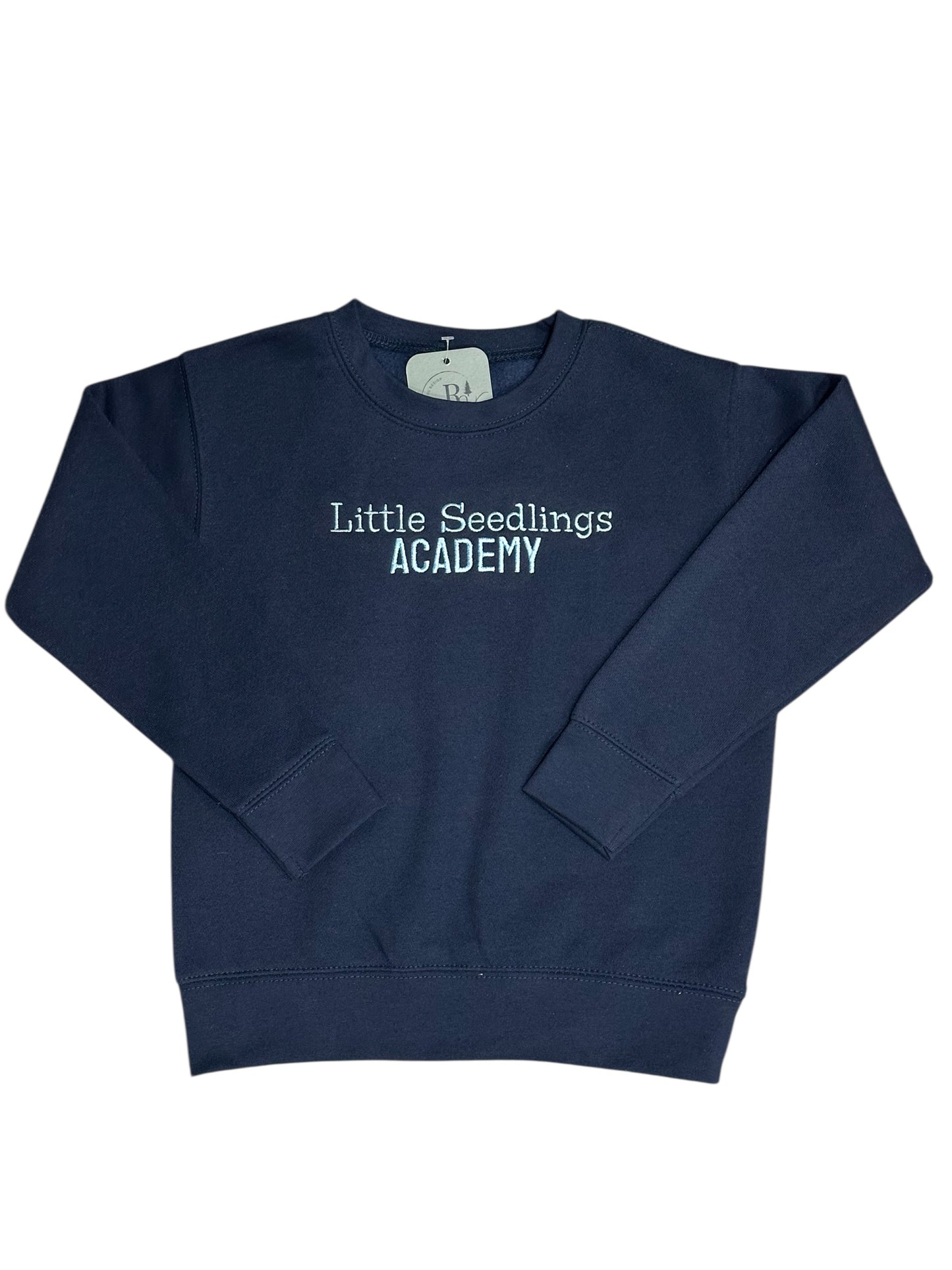 Navy blue sweatshirt with 'Little Seedlings Academy' text embroidered on front center chest in light blue. This view is a zoomed out with the entire sweatshirt with sleeves folded.