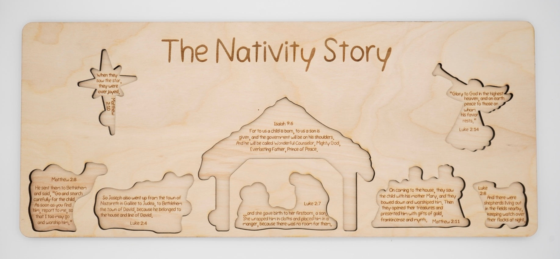 Wooden nativity scene puzzle with engraved scenes and text about the nativity story underneath the pieces