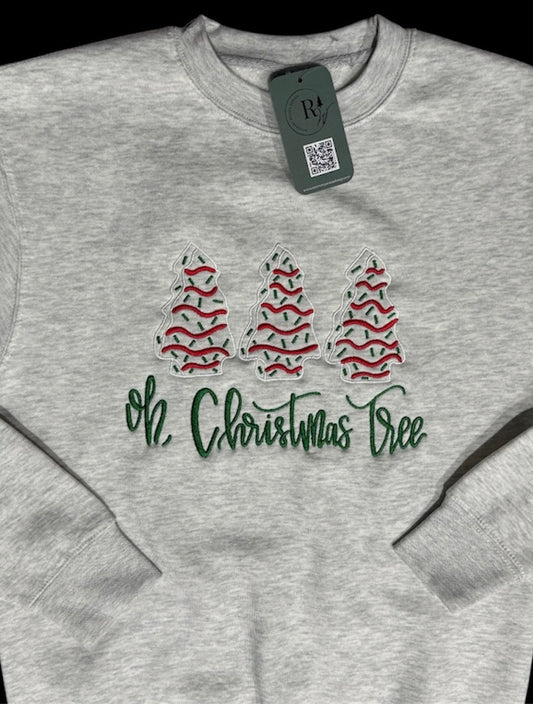 Heathered gray sweatshirt with 3 Christmas trees embroidered in white, red, and green in a line with the text 'Oh, Christmas Tree' embroidered in green underneath. This view is a zoomed in view with sleeves folded on top.